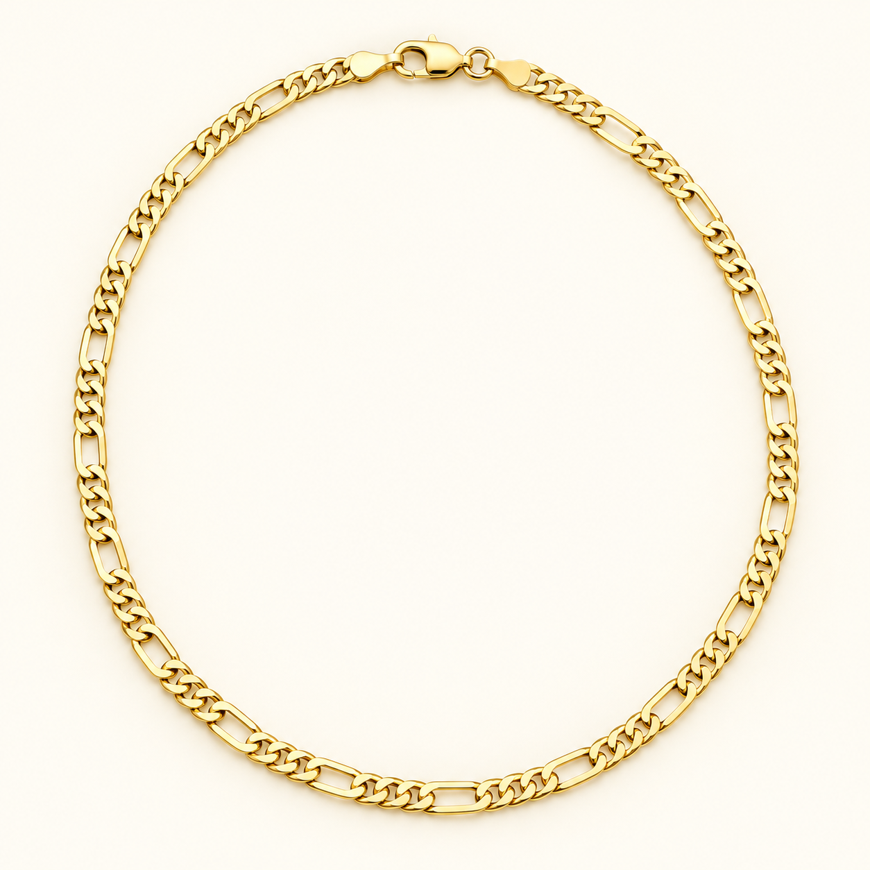 Gold-tone stainless steel Figaro chain on an ivory studio background