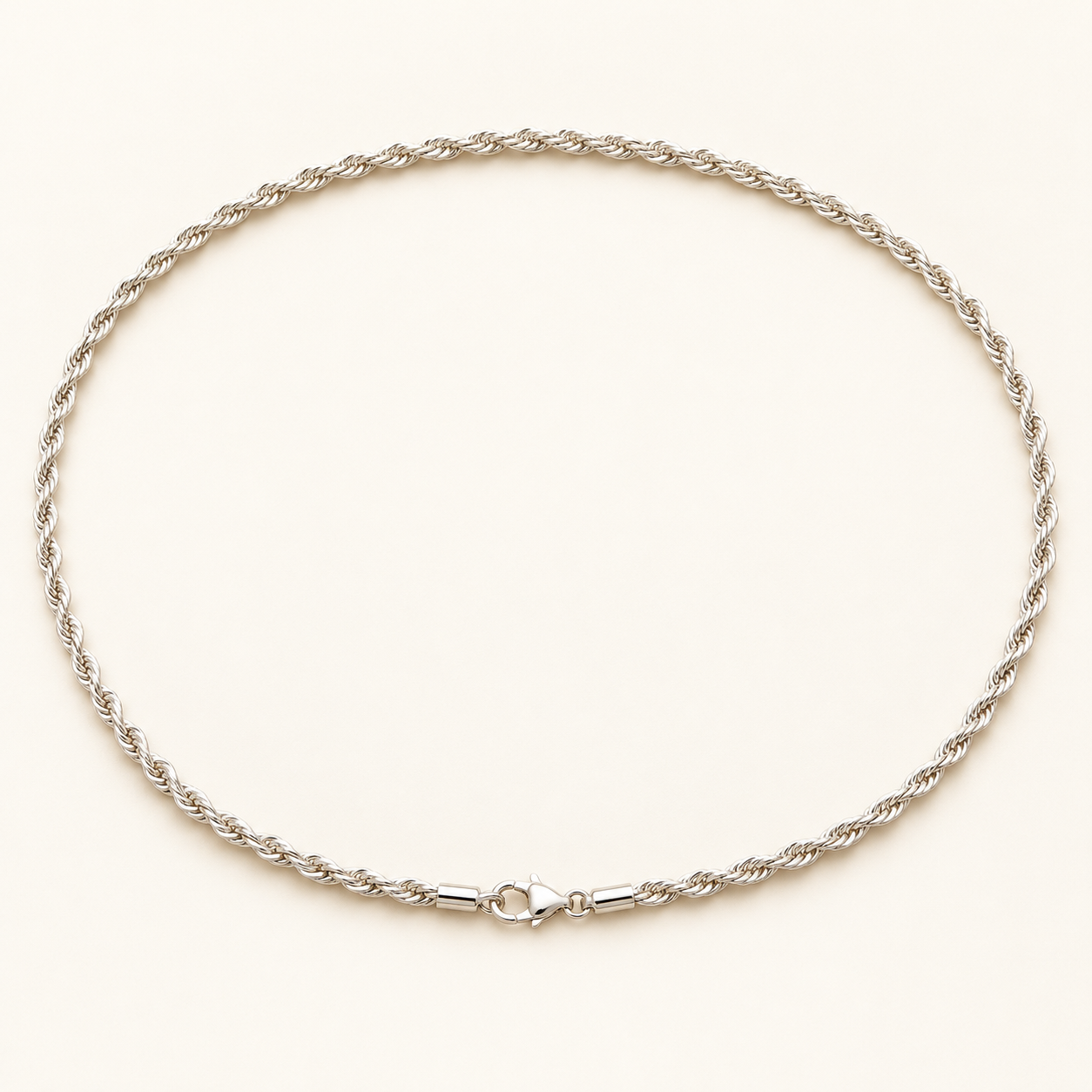 Silver-tone twisted rope chain on an ivory background